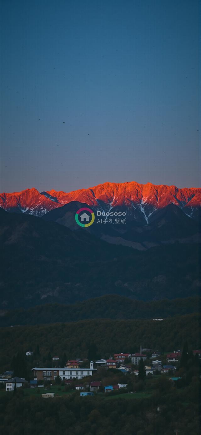 落日余晖下的雪山村庄壮丽风光