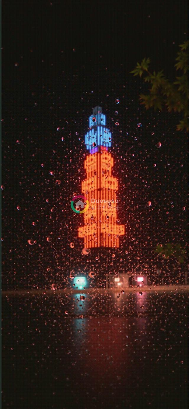 夜雨中霓虹灯映照的塔楼摄影：都市与自然的交融美学