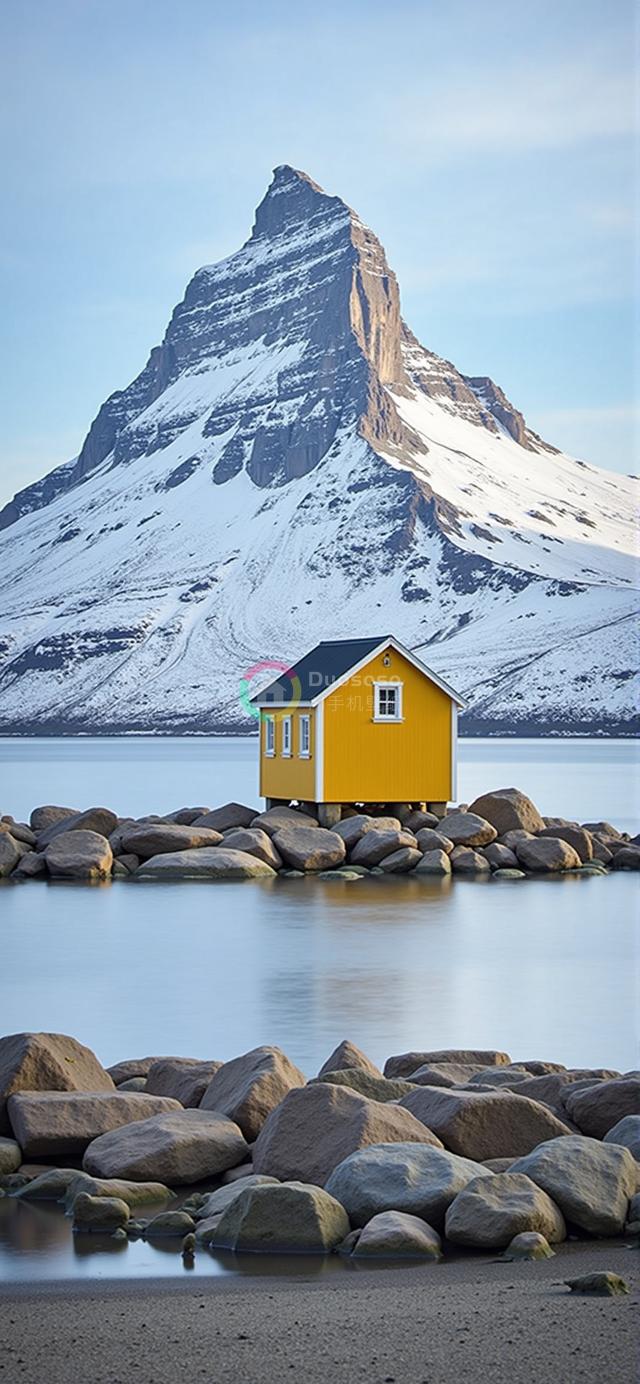 宁静湖畔岩石上夺目黄屋与壮丽雪山相映成趣